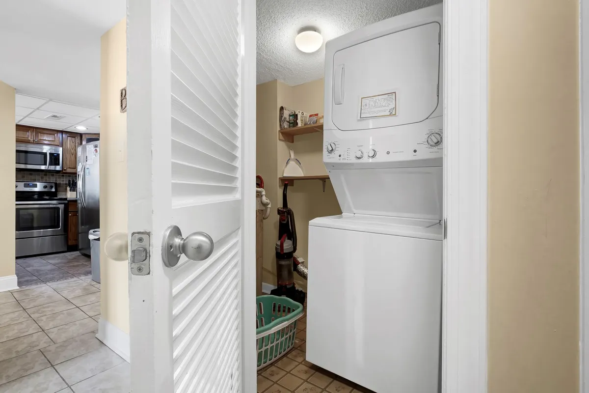 A practical laundry area equipped with a washer, dryer, laundry basket, and shelving for organizing supplies. The space is clean, organized, and conveniently located within the home.